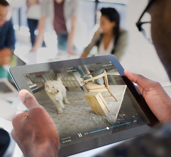 Person looking at tablet displaying Xfinity Home camera